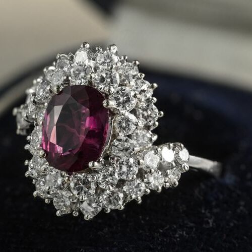 Anello in oro bianco recante rubino ovale ct. 3 e doppio contorno in diamanti ct. 3 complessivi
