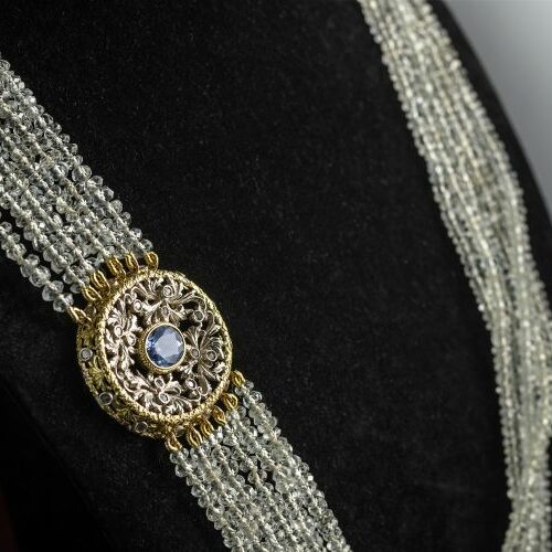 Collana multifili di acquamarine con fermezza in oro giallo e bianco traforata e cesellata recante uno zaffiro Ceylon naturale di ct. 4 circa. Epoca 1930