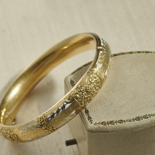Bracciale rigido oro giallo cesellato con parti in smalto bianco. Epoca fine '800
