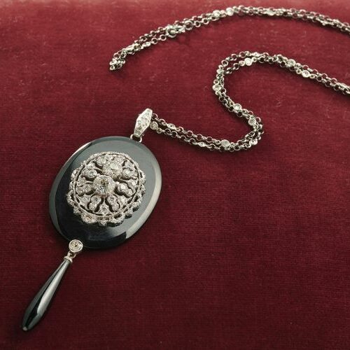 Collanina in oro bianco e diamanti con pendente in oro bianco traforato con diamanti poggiante su onice ovale e a goccia. Epoca anni '20
