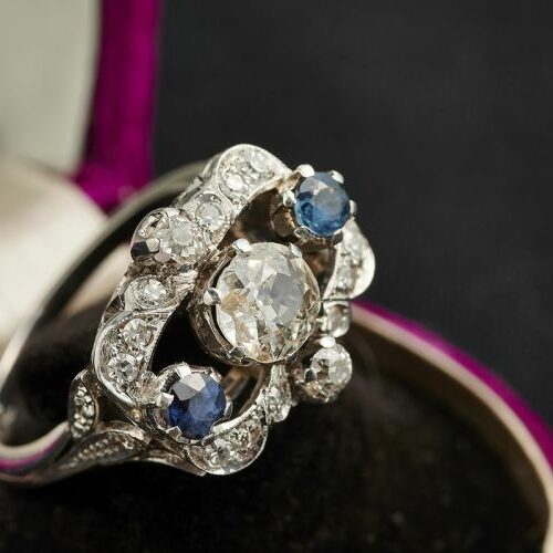 Anello in oro bianco con diamante di vecchio taglio ct. 1,10 ca, due zaffiri e diamanti di contorno. Epoca Art Deco