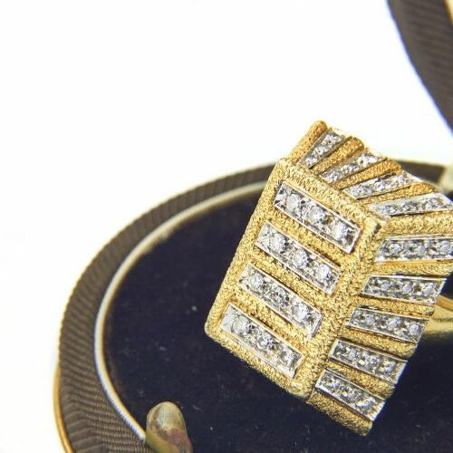 Anello in oro giallo e oro bianco finemente cesellato e impreziosito da file di brillanti. Epoca anni '50