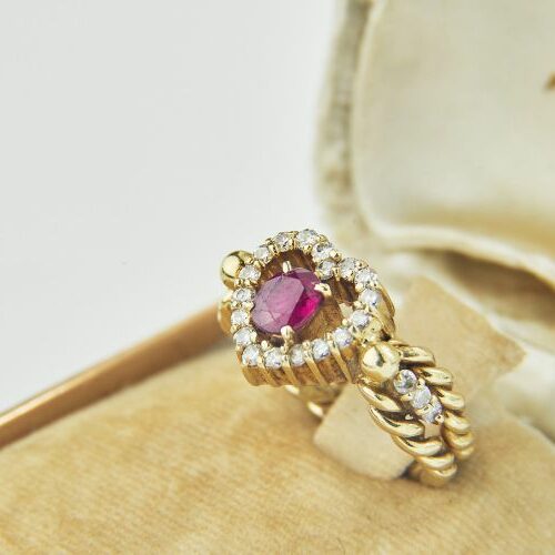 Anello in oro giallo intrecciato con motivo a cuore, rubino e brillanti.
