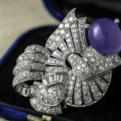 Spilla in platino recante agata ovale cabochon contornata da diamanti tagli diversi per ct. 12 complessivi. Art Deco